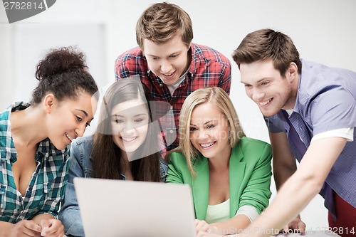 Image of international students looking at laptop at school