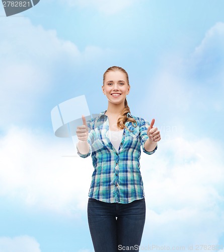 Image of young woman in casual clothes showing thumbs up