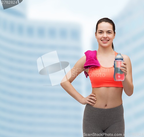 Image of sporty woman with towel and water bottle