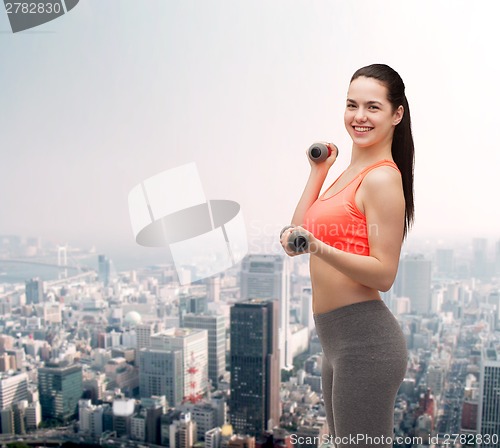 Image of young sporty woman with light dumbbells