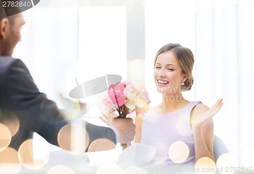 Image of amazed woman recieving bouquet of flowers