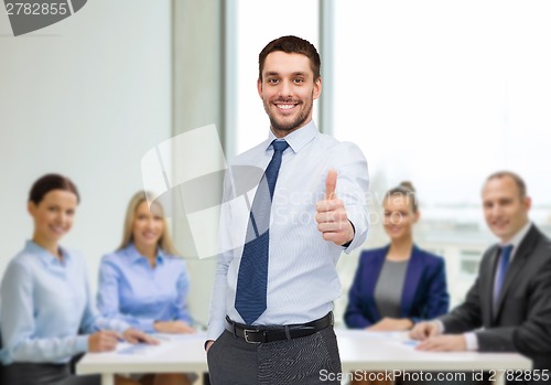 Image of handsome businessman showing thumbs up