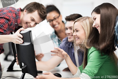 Image of students looking at computer monitor at school