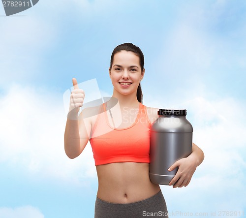 Image of teenage girl with jar of protein showing thumbs up