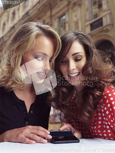 Image of girlfriends look at the mobile phones