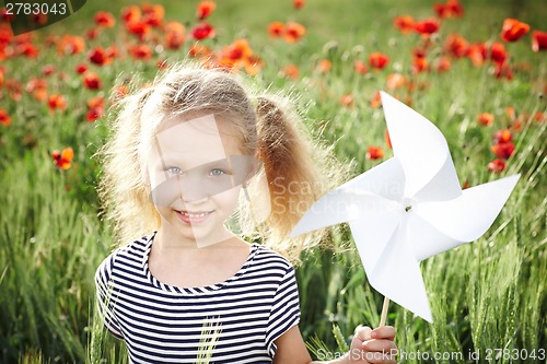 Image of Happy laughing little girl  on the poppy meadow