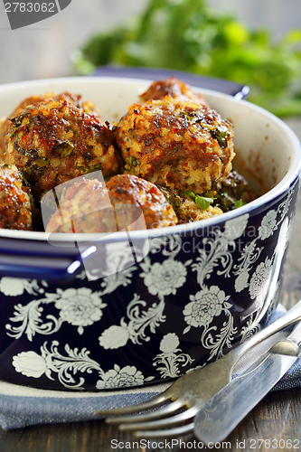 Image of Meatballs in a blue pot on a wooden table.