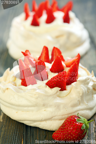 Image of Pavlova dessert with strawberries and lemon cream.