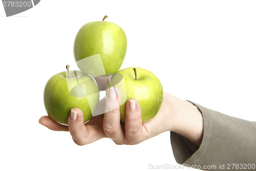 Image of Female hand with three green apples