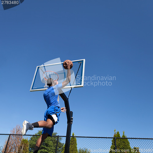 Image of Basketball Player Slam Dunking