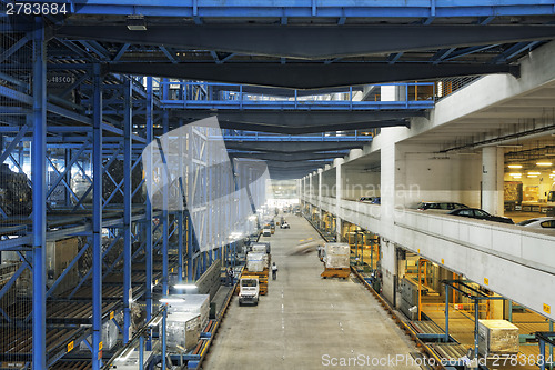 Image of Rows of shelves with boxes in factory warehouse 