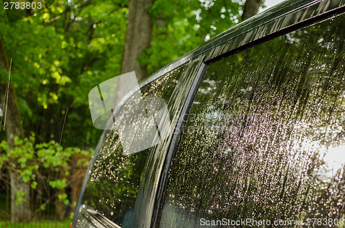 Image of Strong rain water drops fall and splash car roof 