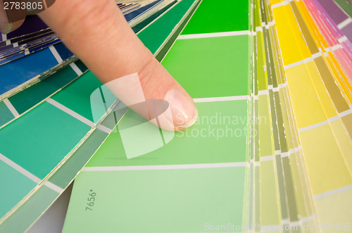 Image of woman finger on color palette of green shade slip 