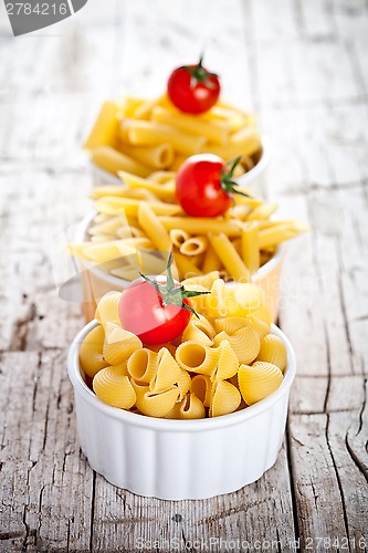 Image of uncooked pasta and cherry tomatoes in three bowls 