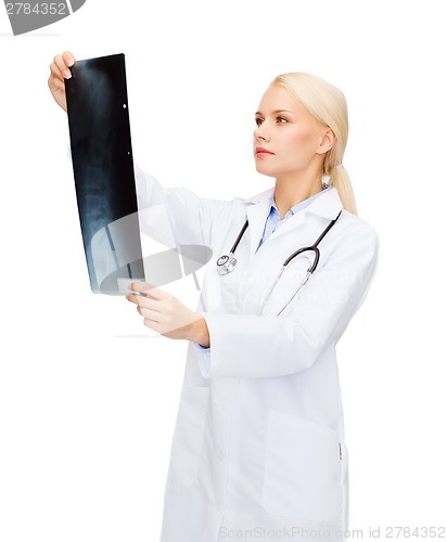 Image of serious female doctor looking at x-ray