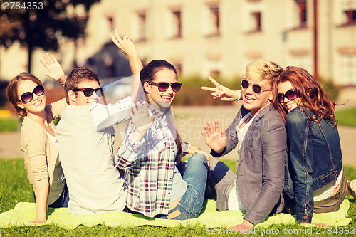 Image of group of students or teenagers waving hands