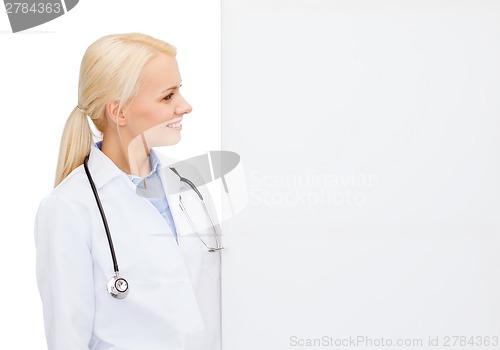 Image of smiling female doctor with white blank board