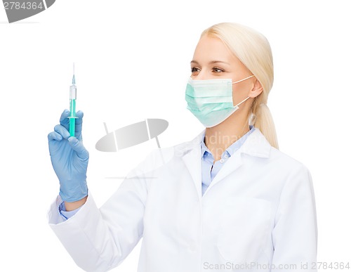 Image of doctor in mask holding syringe with injection