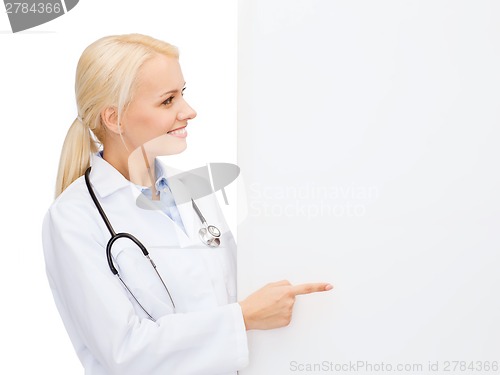 Image of smiling female doctor with white blank board