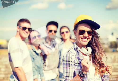 Image of teenage girl with headphones and friends outside