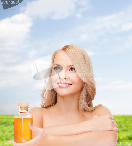 Image of happy woman with oil bottle