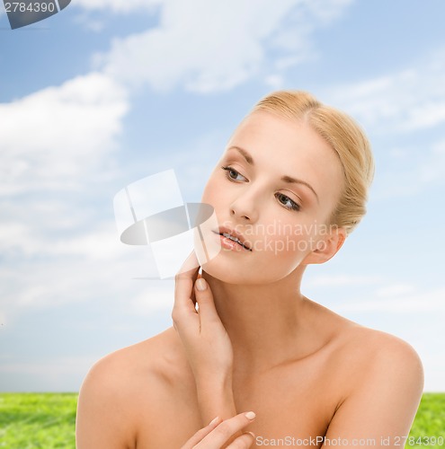 Image of beautiful woman touching her face skin