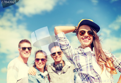 Image of teenage girl with headphones and friends outside