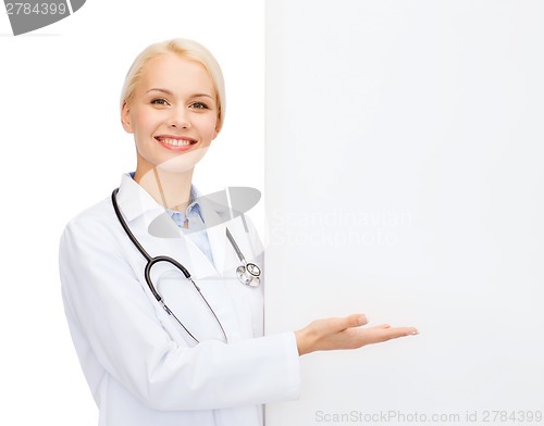 Image of smiling female doctor with white blank board