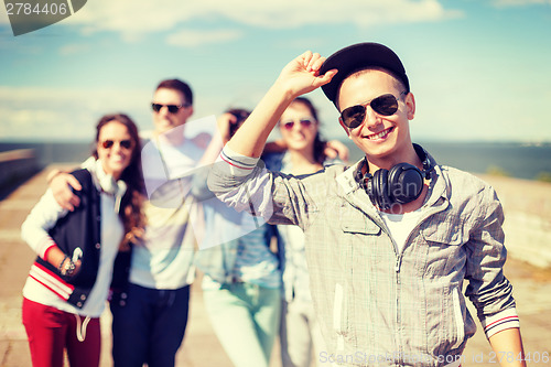 Image of teenage boy with sunglasses and friends outside