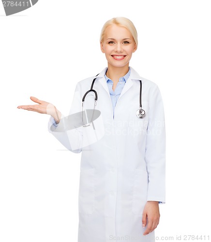 Image of smiling female doctor holding something on hand