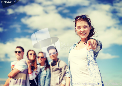 Image of teenage girl with headphones and friends outside