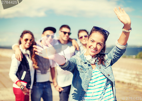 Image of teenage girl with headphones and friends outside