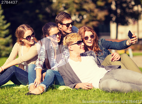 Image of teenagers taking photo outside with smartphone