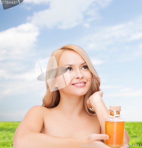 Image of happy woman with oil bottle