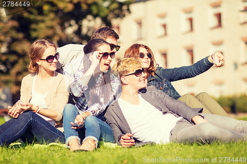 Image of teenagers taking photo outside with smartphone