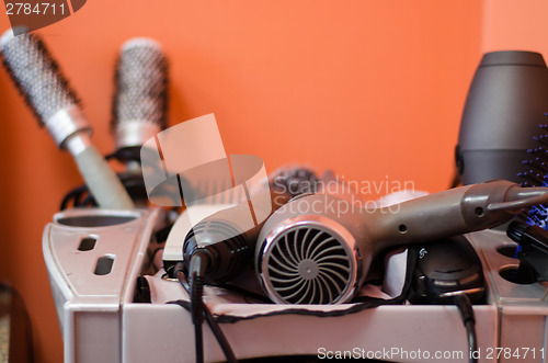 Image of close up of hairdressing accessories in gray shelf 