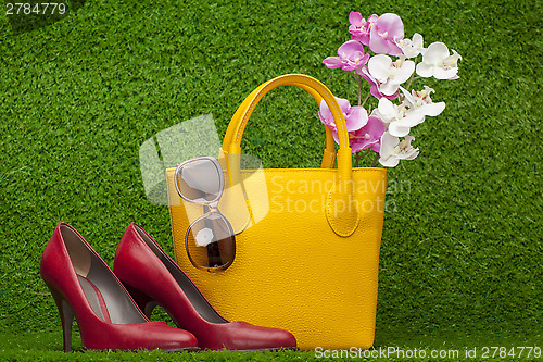 Image of sunglasses, handbag; and red shoes