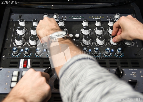 Image of Hands on a sound mixer