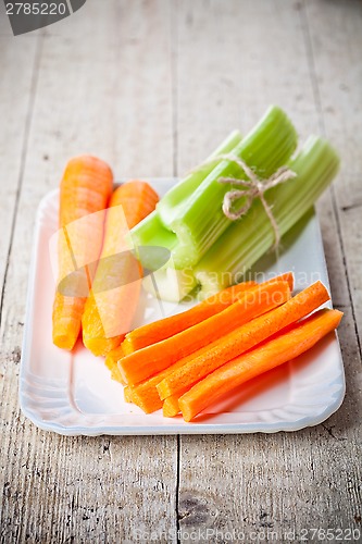 Image of bundle of fresh green celery stems and carrot