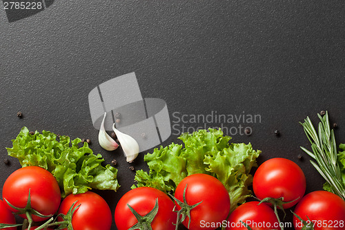 Image of red tomatoes with green salad on black