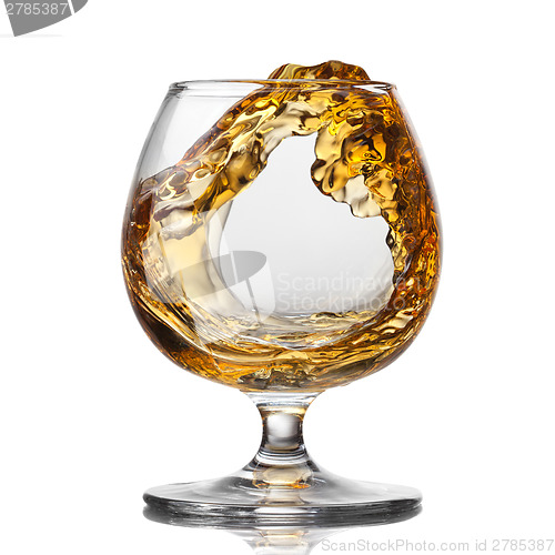 Image of Splash of cognac in glass isolated