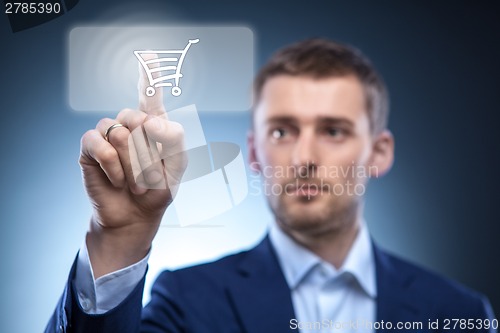 Image of businessman press button with shopping cart