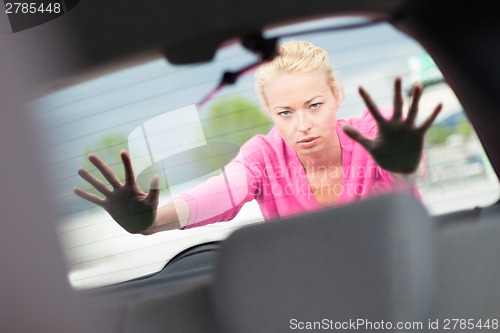 Image of Woman pushing a car.