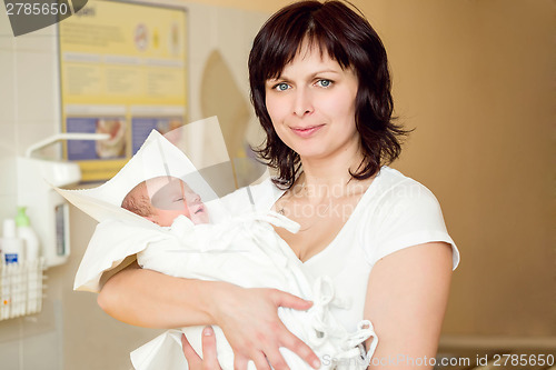 Image of Loving mother embracing her newborn baby