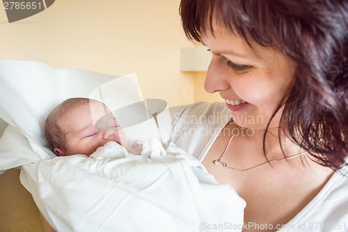 Image of Loving mother embracing her newborn baby