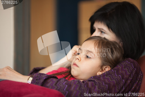 Image of Mother with her daughter sitting on sofa