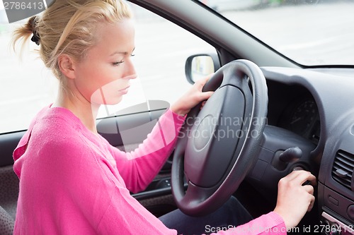 Image of Female car driver starting the engine.