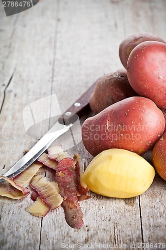 Image of  peeled potatoes and knife