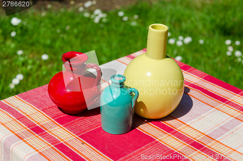 Image of ceramic colored vase red striped surface outdoor 