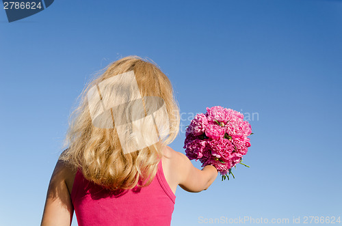 Image of back view of woman and hand with peony bouquet 